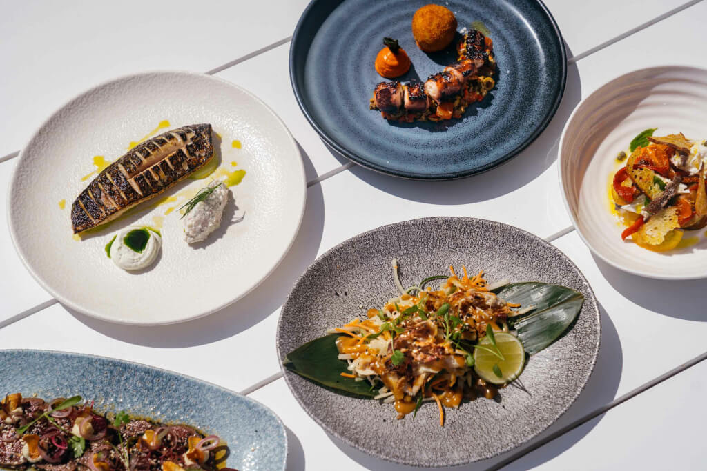 Photo of various meals served on differently colour plates